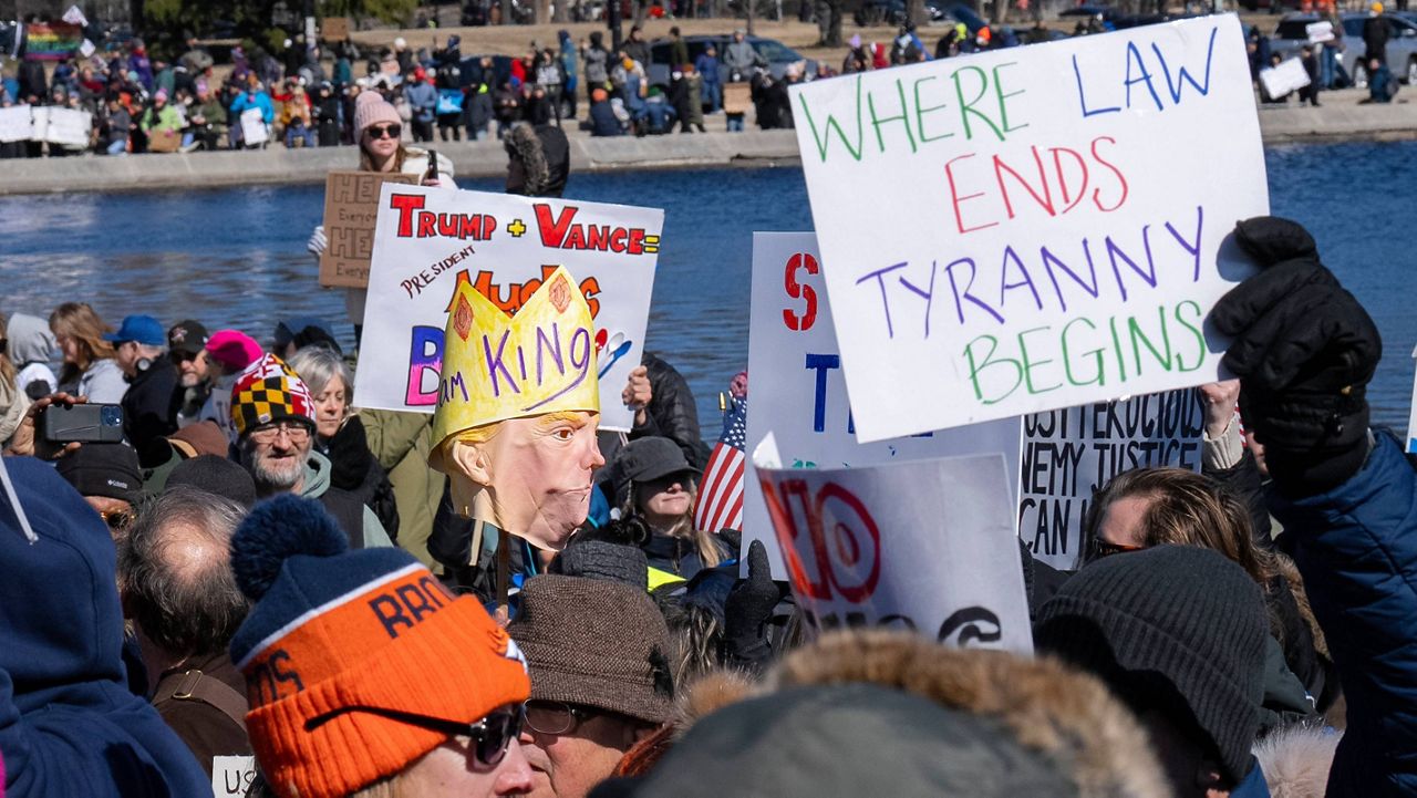 A person holds up a costume head representing President Donald Trump during a protest on Presidents Day in Washington. (AP Photo/Jacquelyn Martin)