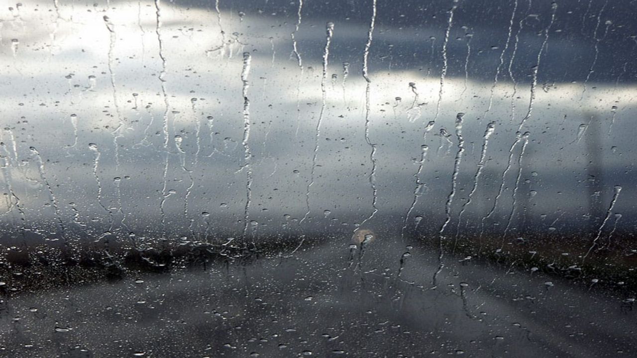 Heavy rain falls on a windshield