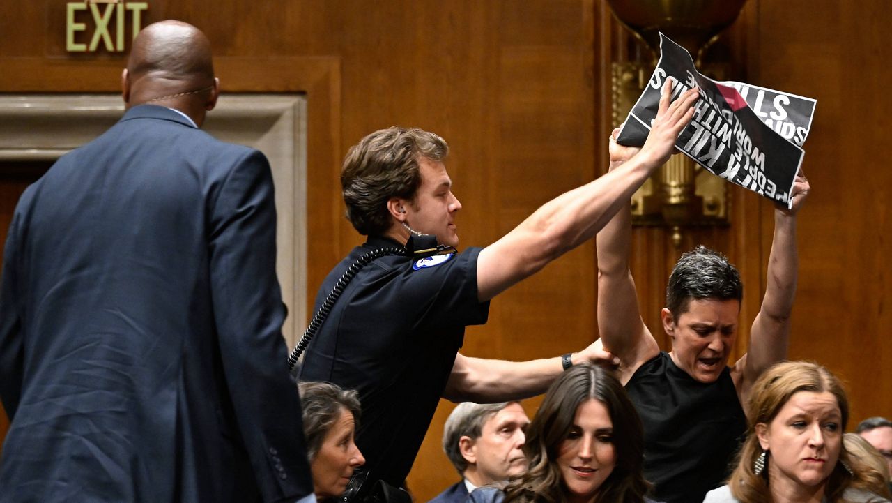 Police remove protesters as Secretary of Health and Human Services Robert F. Kennedy Jr. appears before a Senate committee on Health, Education, Labor and Pensions hearing at the U.S. Capitol on Wednesday, May 14, 2025, in Washington. (AP Photo/John McDonnell)