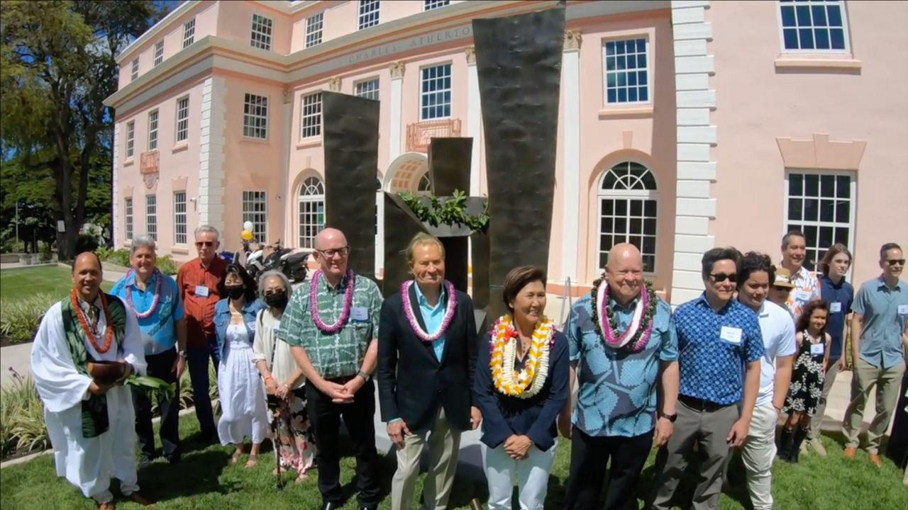 Dignitaries were on hand for the installation of Bumpei Akaji's sculpture at the Walter Dods, Jr. RISE Center including, (from left, in front of sculpture, wearing lei) Tim Dolan, UH VP for Advancement and UH Foundation CEO; Jay Shidler, UH Manoa alumnus and philanthropist; Susan Yamada, UH Pacific Asian Center for Entrepreneurship Board Chair; and Walter Dods, UH alumnus and longtime UH donor. (Screenshot courtesy of the University of Hawaii)