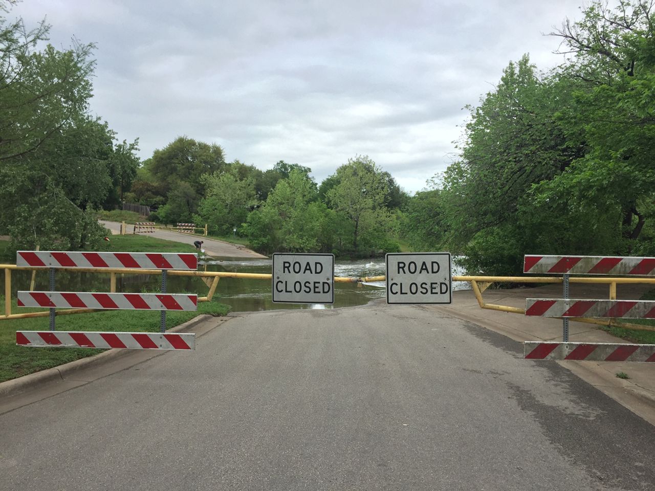 Low water crossing closed with water spilling onto the roadway in Round Rock. 