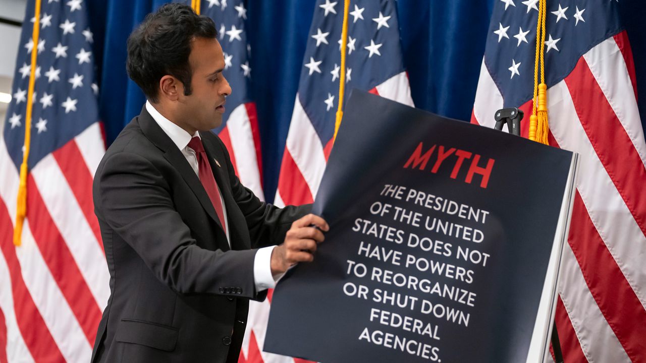 Republican presidential candidate Vivek Ramaswamy peels a sheet from a poster display as he speaks at the America First Policy Institute in Washington, Wednesday, Sept. 13, 2023. (AP Photo/Mark Schiefelbein)