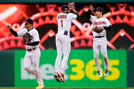 Cleveland Guardians' Amed Rosario (1) and Steven Kwan, right, celebrate  after defeating the Tampa Bay Rays in a wild card baseball playoff game,  Friday, Oct. 7, 2022, in Cleveland. (AP Photo/David Dermer