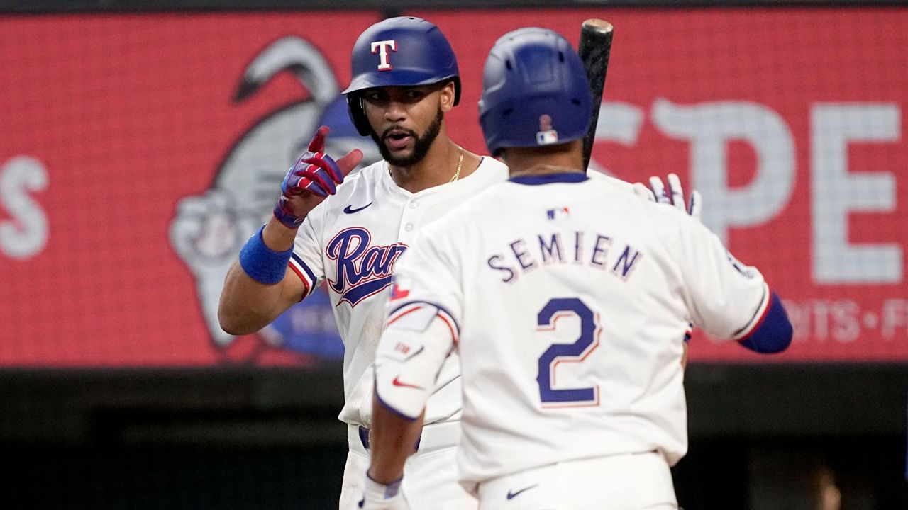 Texas Rangers' Leody Taveras, left, and Marcus Semien (2) celebrate after Semien hit a two-run home run that also scored Taveras against the Tampa Bay Rays in the seventh inning of a baseball game in Arlington, Texas, Saturday, July 6, 2024. (AP Photo/Tony Gutierrez)