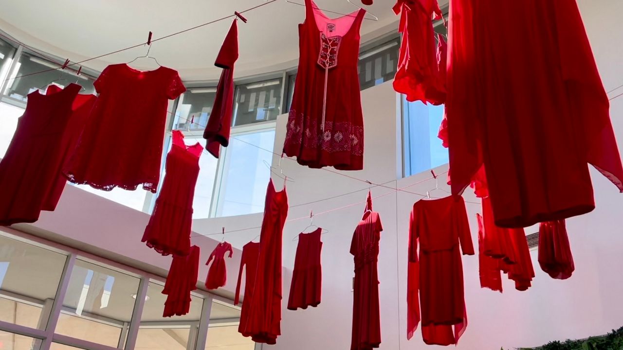 Red dresses hang inside the George Washington Carver Museum and Cultural Center in Austin, Texas, to represent murdered and missing Indigenous women. (Spectrum News 1/Tanya Velazquez)