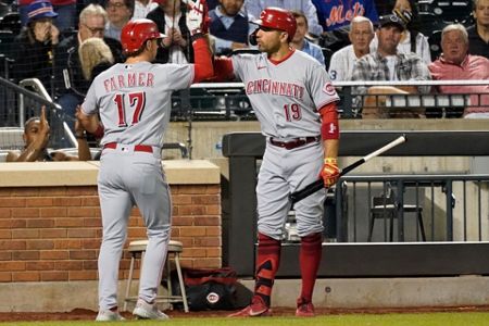 Cincinnati Reds' Eugenio Suarez blows a bubble with his gum as he