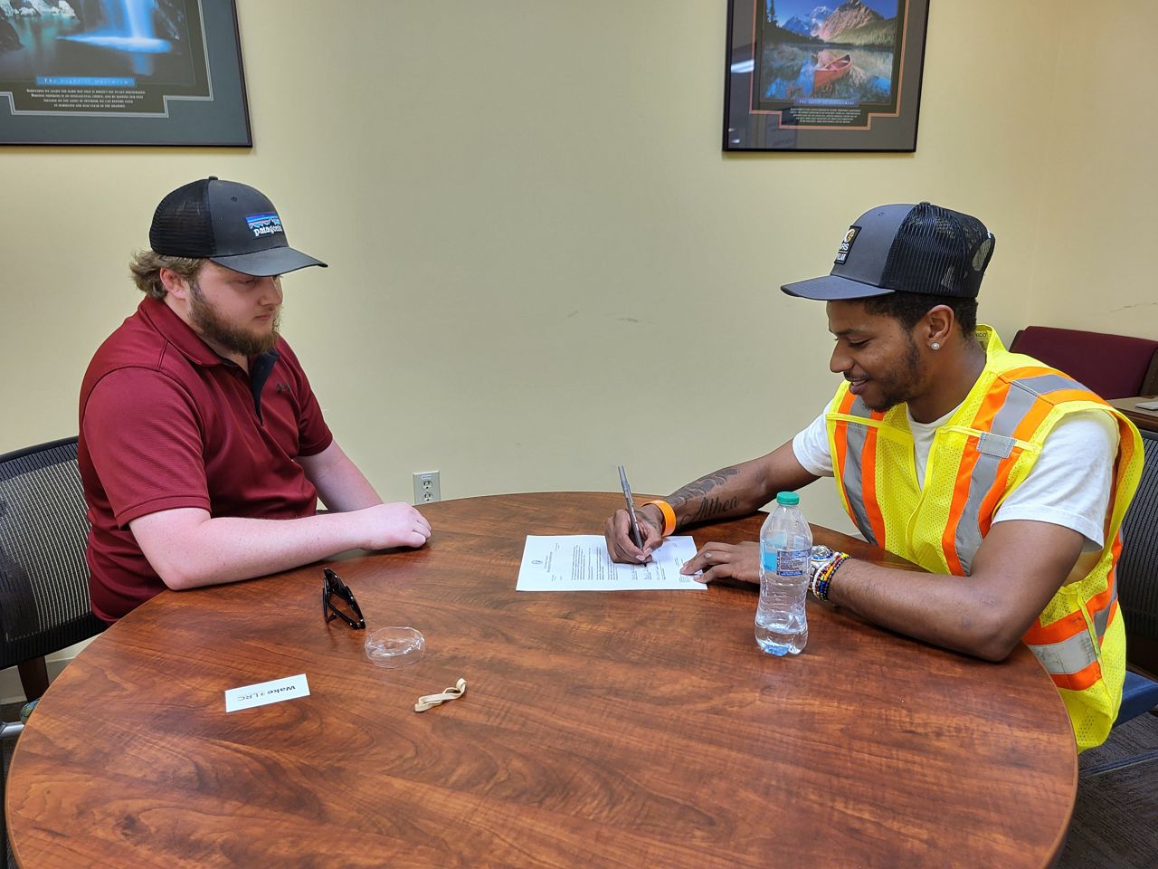 Jahwon Hartsfield (right) signs his offer letter with the state Department of Transportation. (N.C. Department of Transportation)