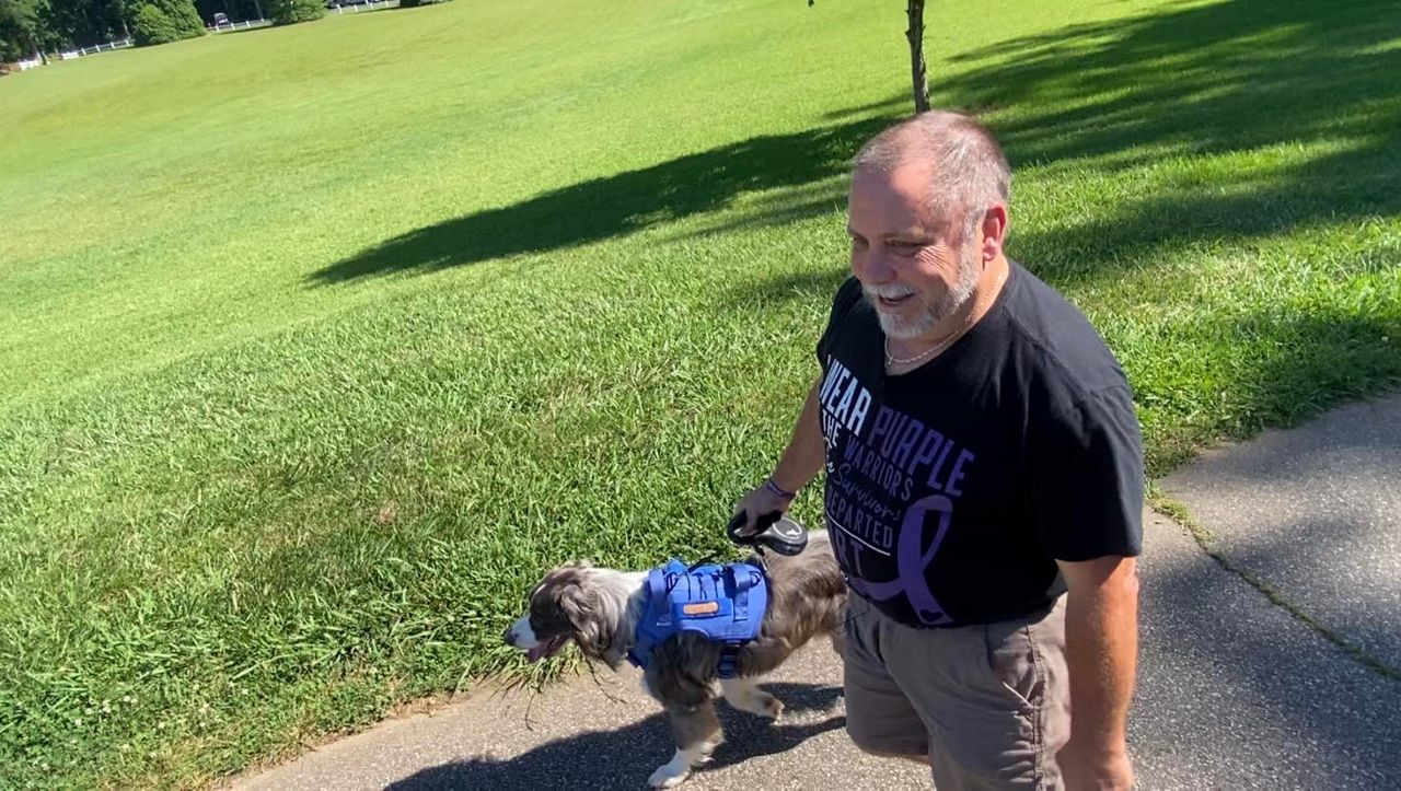 Richard Eudy walking with his dog Max in the park (Spectrum News 1/Zyneria Byrd)