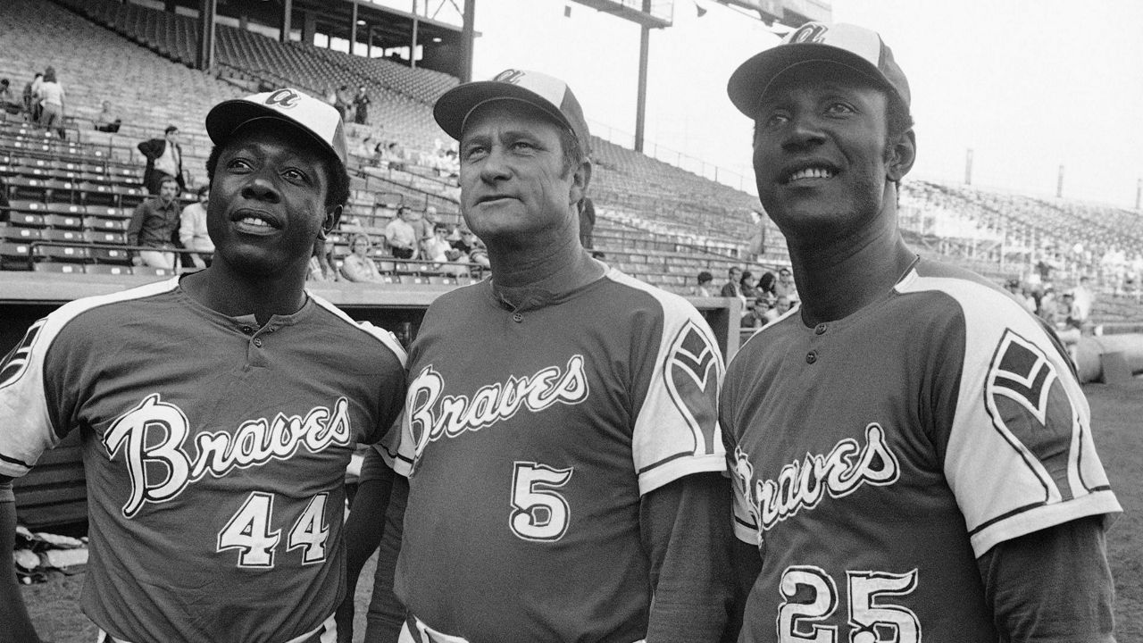 Atlanta Braves' Rico Carty, right, Hank Aaron, left, and Lew Burdette look up into stands at night on May 22, 1972 before exhibition game against the Brewers in Milwaukee. (AP Photo, File)