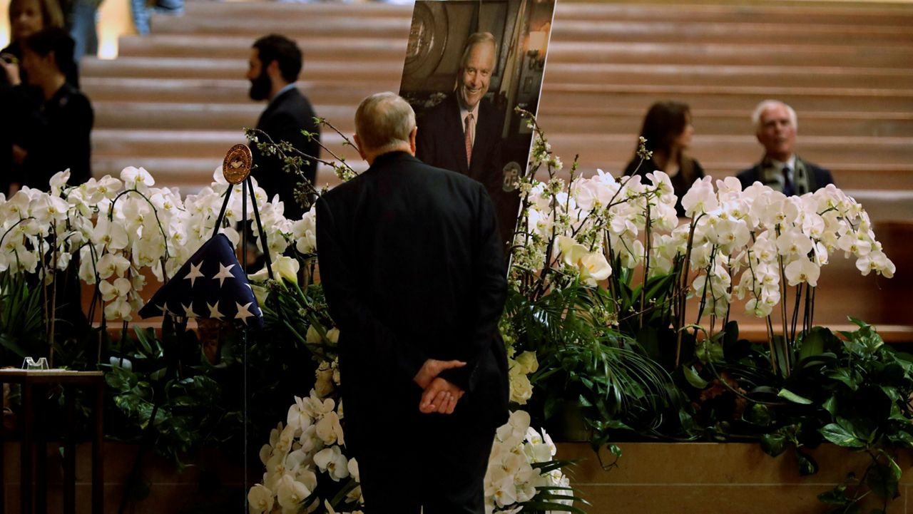 Msgr. Lloyd Torgerson, pastor at St. Monica Catholic Church, looks over a portrait of former Mayor Richard Riordan before the memorial Mass for the former Los Angeles mayor at Our Lady of the Angels in downtown Los Angeles, Friday, April 28, 2023. St. Monica Catholic Church was Riordan's parish. (Genaro Molina/Los Angeles Times via AP, Pool)