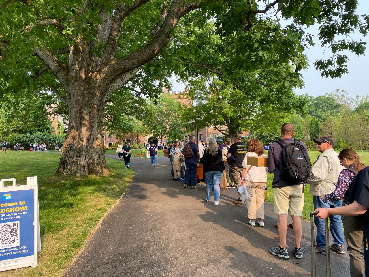 people waiting in line outside a mansion