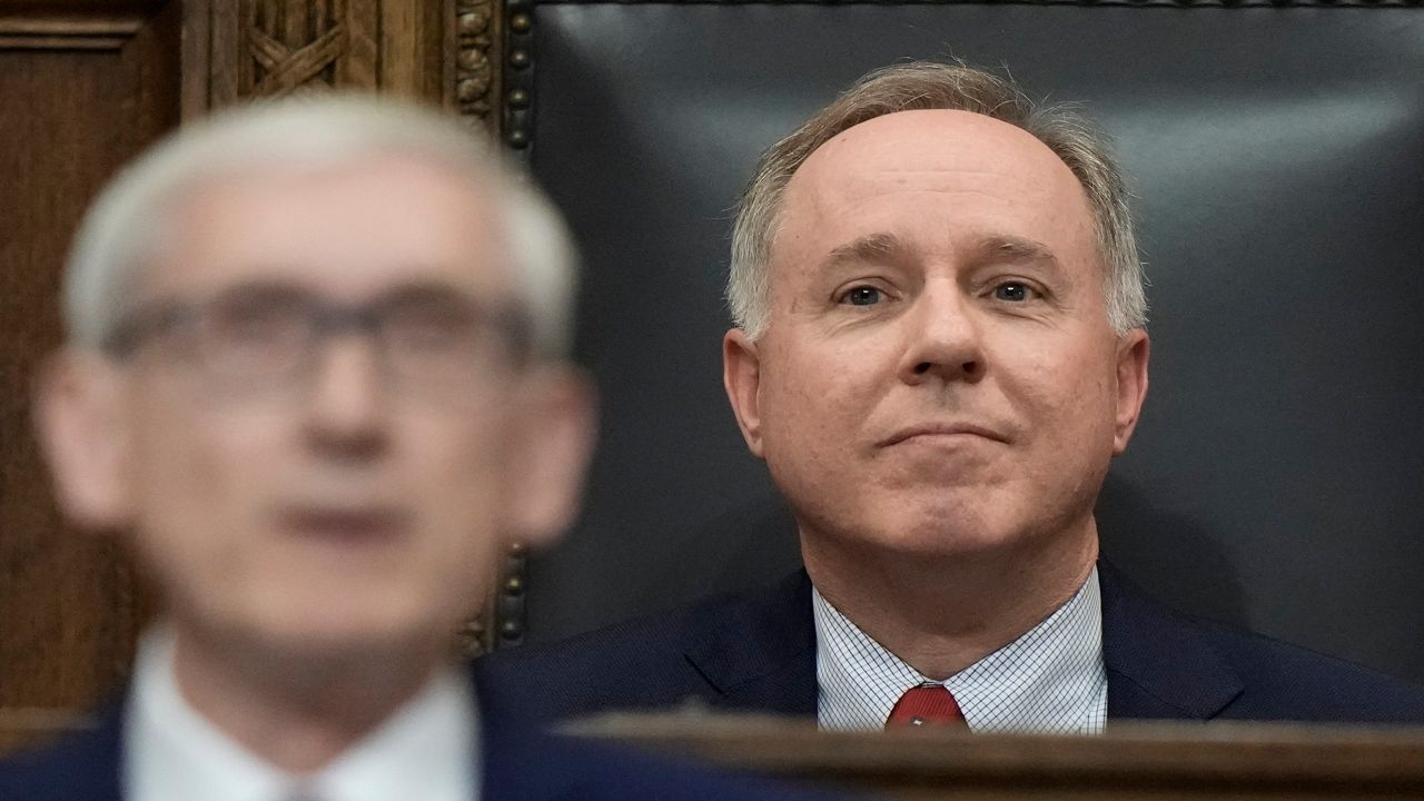 Robin Vos sits behind Gov. Tony Evers