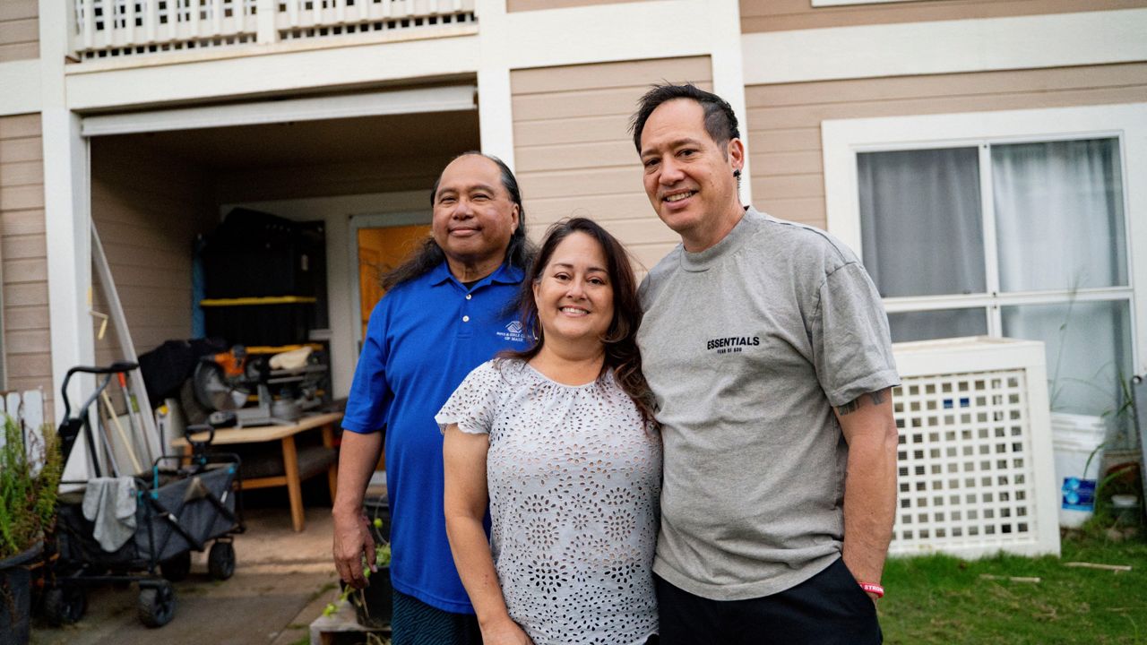 From left to right, Ron Sambrano, Tamara, and Kawehi Akiona pose for a portrait at their home, Thursday, Dec. 12, 2024, in Wailuku, Hawaii. Sambrano and the Akionas are part of the 253 households receiving funds from the Council for Native Hawaiian Advancement. (AP Photo/Mengshin Lin)