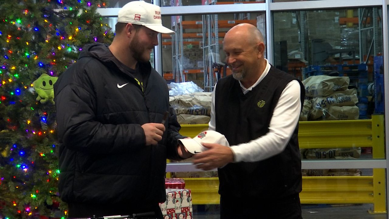 Matt Habash, the president and CEO of the food bank, has Seth sign an OSU hat since he was unable to secure one of Seth's RTDB hats