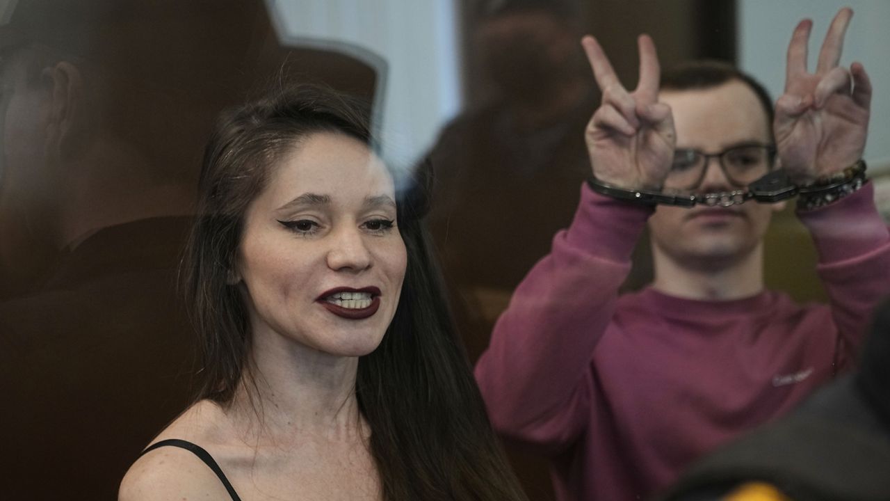 Russian journalists, Antonina Favorskaya, left, and Artyom Kriger, accused of working for a group founded by the late Russian opposition politician Alexei Navalny, stand in a defendant's cage of the Nagatinsky District Court in Moscow, Russia, on Tuesday, April 15, 2025. (AP Photo)