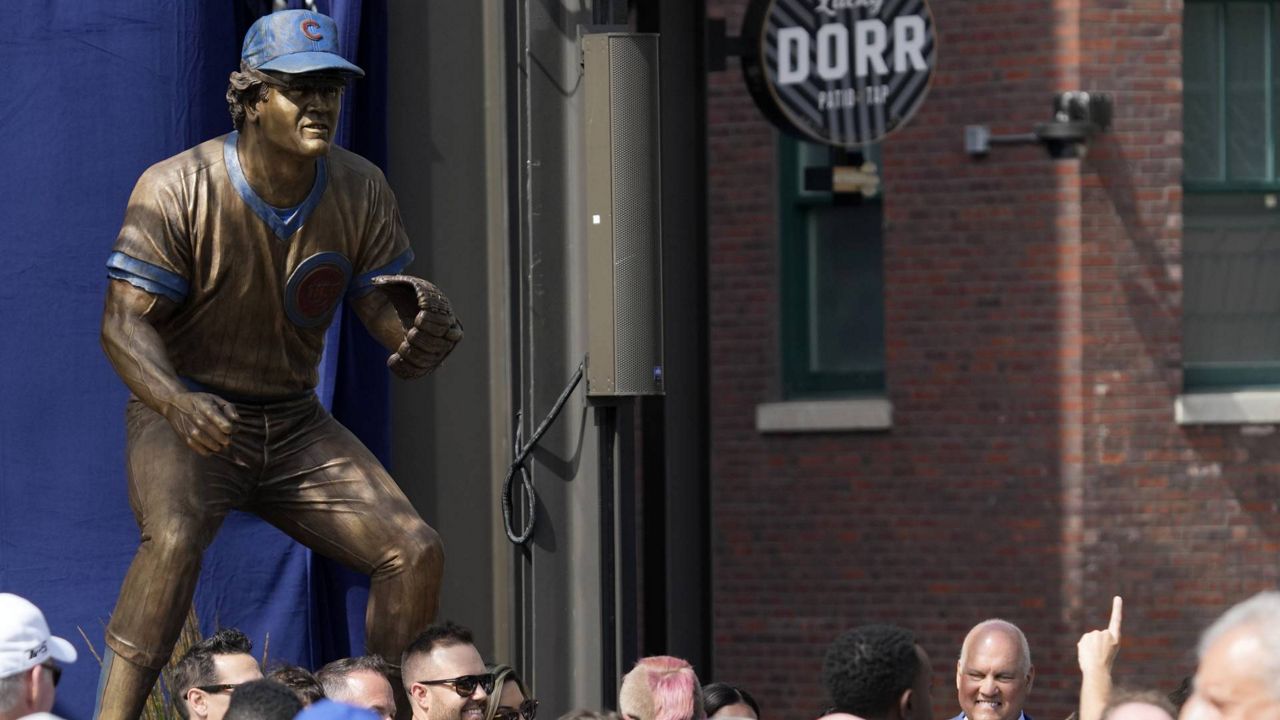 Ryne Sandberg, right, takes photos with family after the Chicago Cubs unveiled a statue honoring the legendary Cubs and Hall of Fame player during a dedication ceremony before a baseball game between the New York Mets and the Chicago Cubs in Chicago, Sunday, June 23, 2024. (AP Photo/Nam Y. Huh)