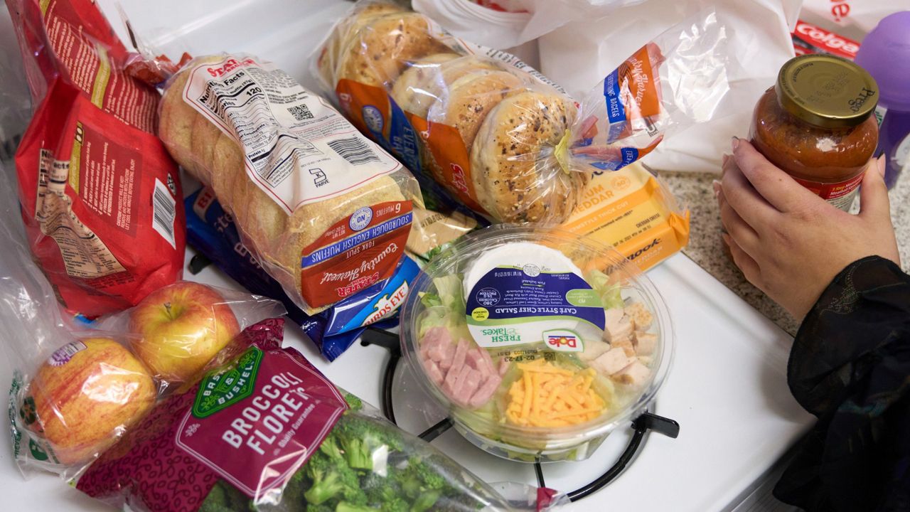 Jaqueline Benitez puts away groceries at her home in Bellflower, Calif., on Monday, Feb. 13, 2023. (AP Photo/Allison Dinner)