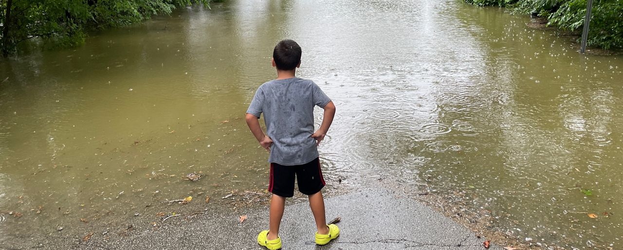 A boy looks out at the entrance to the Woodlands Sports Park in St. Peters, Mo. after flash flooding on July 26, 2022