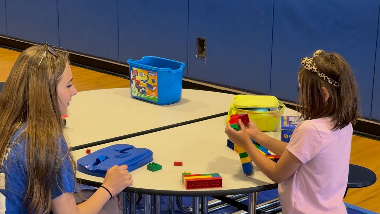 A camp counselor and camper play with blocks at Auburn Middle School on Wednesday. (Spectrum News 1/Devin Bates)