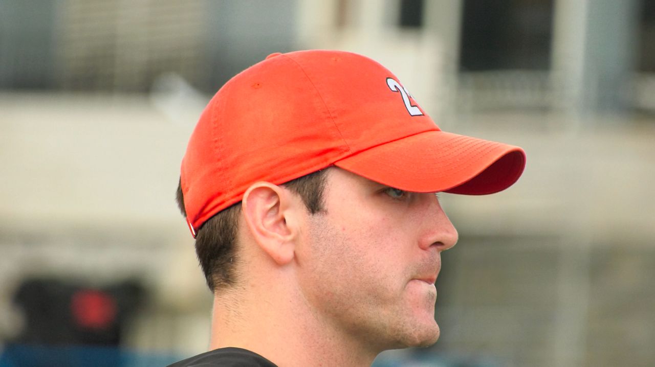 connor buczek, wearing a baseball cap, looks into the distance