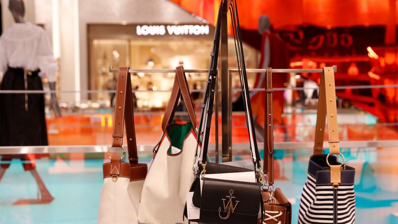 In this Wednesday, Feb. 20, 2019, photo luxury handbags hang from a display inside the Saks Fifth Avenue's flagship Manhattan location in midtown Manhattan, in New York. (AP Photo/Kathy Willens)