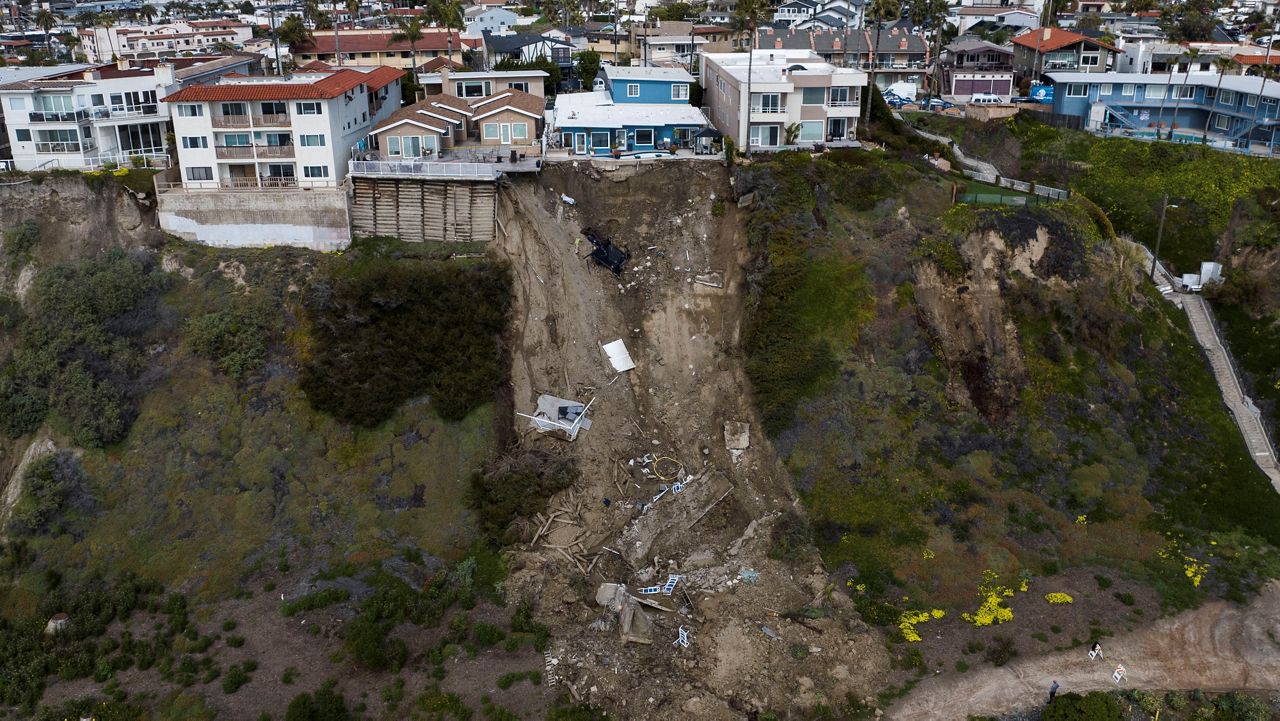 In this image taken with a drone, a mass of debris is seen along a cliff beneath residential homes after a landslide occurred in San Clemente, Calif., Thursday, March 16, 2023. . (AP Photo/Jae C. Hong)