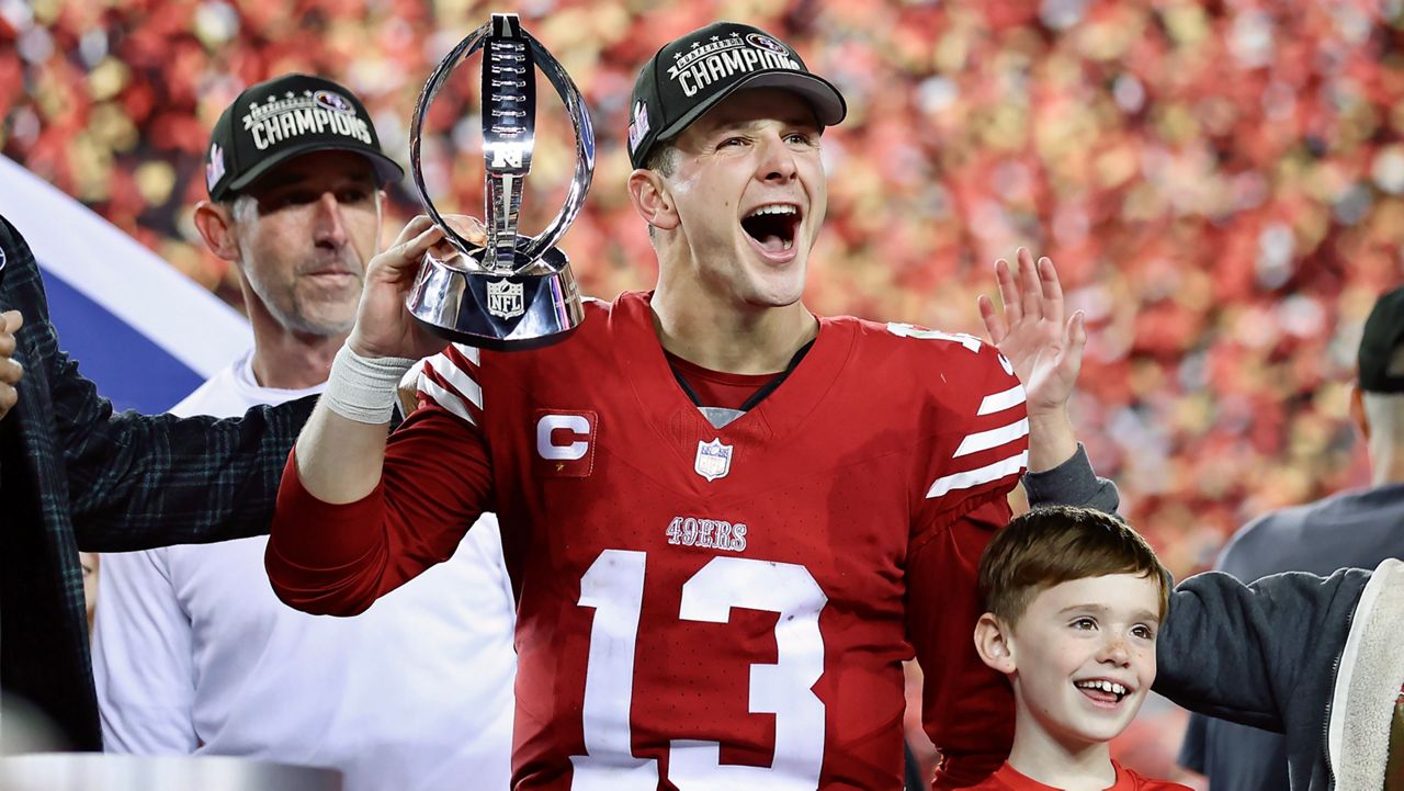 San Francisco 49ers quarterback Brock Purdy (13) and head coach Kyle Shanahan, left, celebrate after the NFC Championship NFL football game against the Detroit Lions in Santa Clara, Calif., Sunday, Jan. 28, 2024. (AP Photo/Jed Jacobsohn)