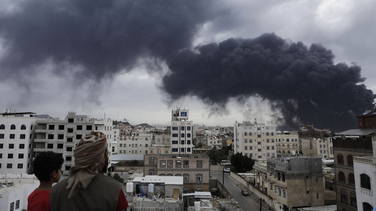 Yemenis watch as smoke billows following Israeli airstrikes targeting a power plant and Sanaa Airport, in Sanaa, Yemen, Tuesday, May 6, 2025. (AP Photo/Osamah Abdulrahman)
