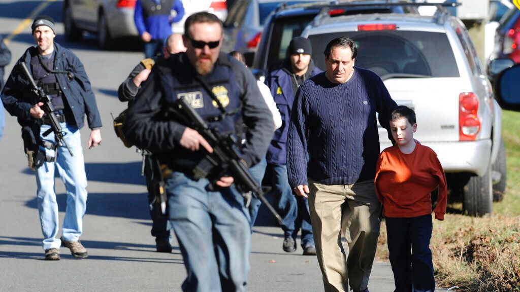 Parents leave a staging area after being reunited with their children following a shooting at the Sandy Hook Elementary School in Newtown, Conn., where authorities say a gunman opened fire, Dec. 14, 2012.(AP Photo/Jessica Hill)