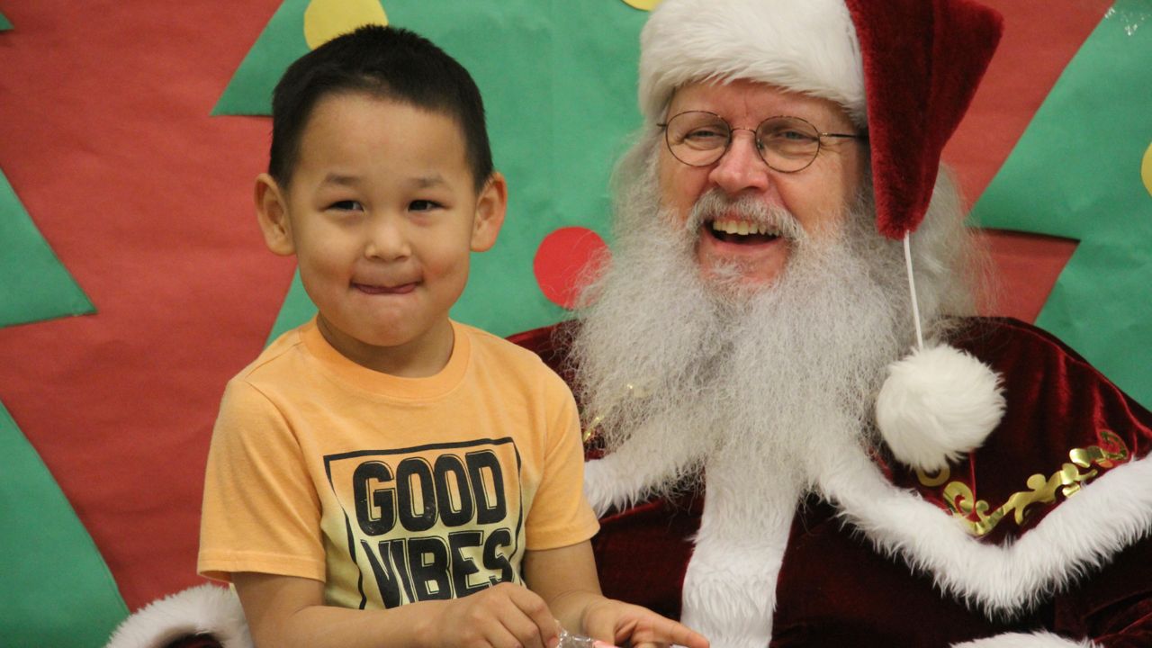 A kid sits with Santa.