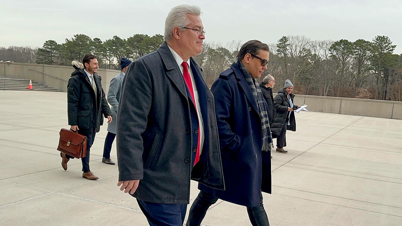 Former U.S. Rep. George Santos, right, leaves federal court with his attorney, Joseph Murray, Tuesday, Jan. 23, 2024, in Central Islip, N.Y. Santos appeared, Tuesday, in federal court on Long Island, New York for another hearing ahead of his criminal fraud trial later this year. Unlike a prior appearance in December, Santos' lawyer John Murray spoke only briefly about the potential for a plea deal, saying negotiations remain "productive" and that both sides would report back to the judge if there were any notable developments. (AP Photo/Philip Marcelo)