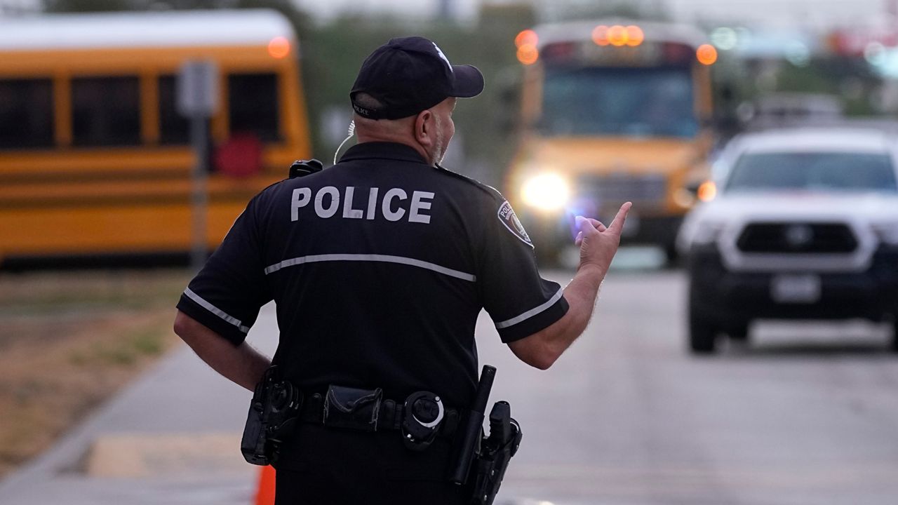 Southside Independent School District police officer Ruben Cardenas keeps watch as students arrive at Freedom Elementary School, Wednesday, Aug. 23, 2023, in San Antonio. Most Texas school districts say they are unable to comply with a new law requiring armed officers on every campus. The mandate was one of Republican lawmakers' biggest acts following the Uvalde school shooting in 2022 that killed 19 children and two teachers. (AP Photo/Eric Gay)
