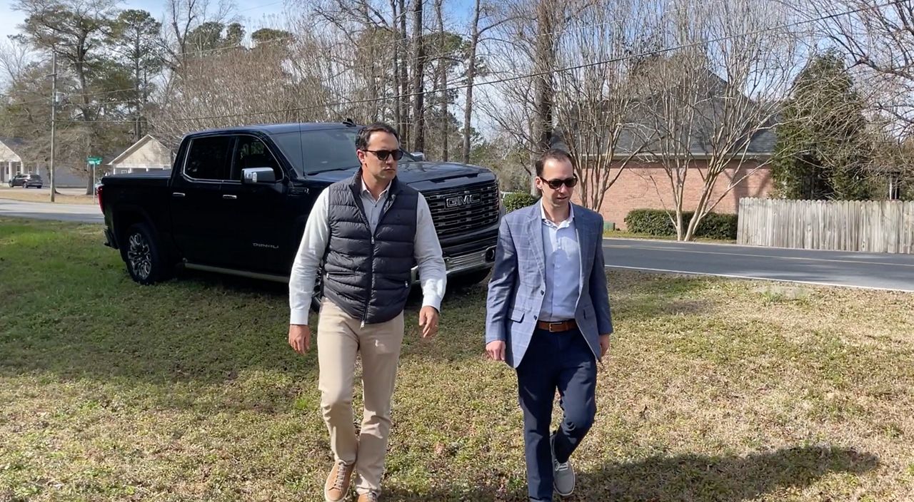 Devlin Horton and Nick Mendez at the location of a crash site one of their clients was injured in (Spectrum News 1/Alex Wilkinson)