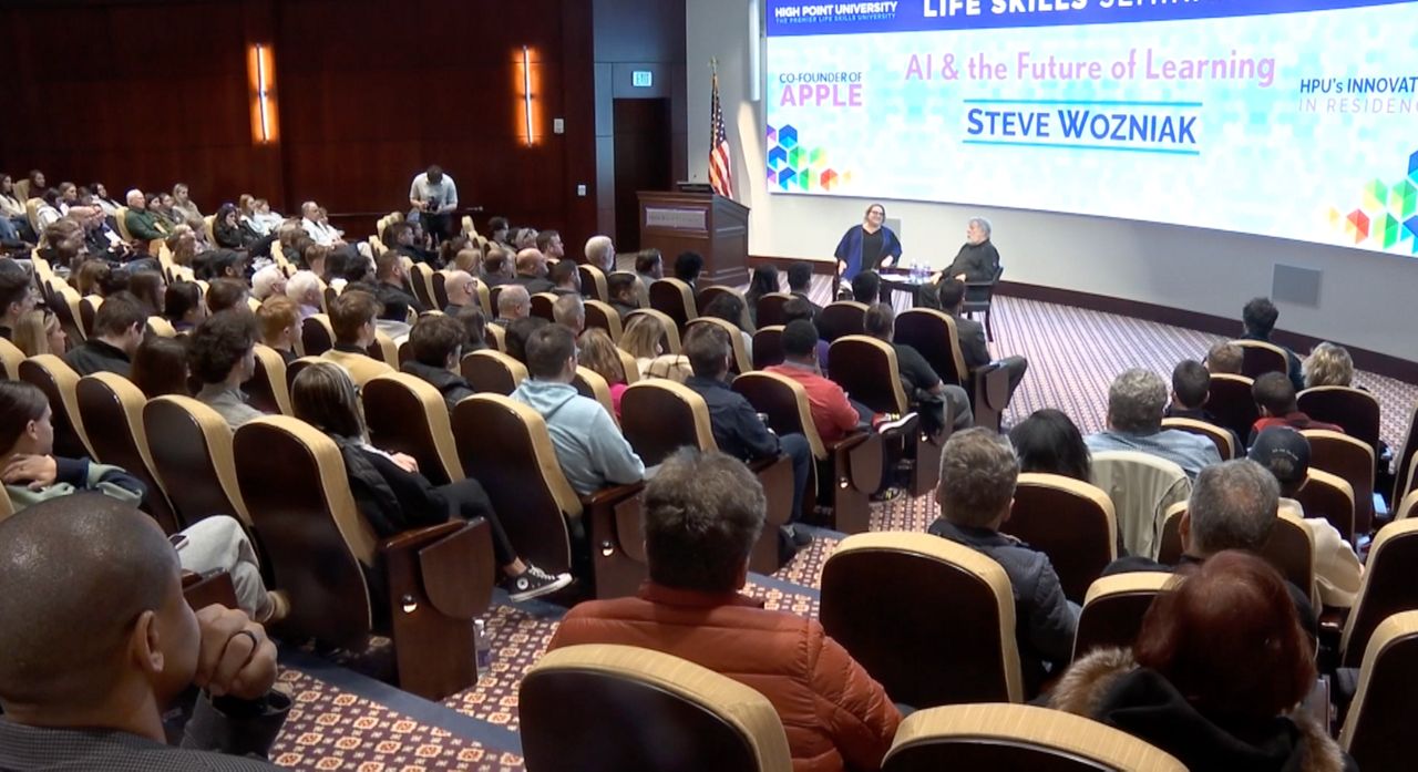 Apple co-founder Steve Wozniak and Amy Holcombe, dean of High Point University's School of Education, discuss the future of generative artificial intelligence at a seminar Feb. 19. (Spectrum News 1/Kaye Paddyfote)