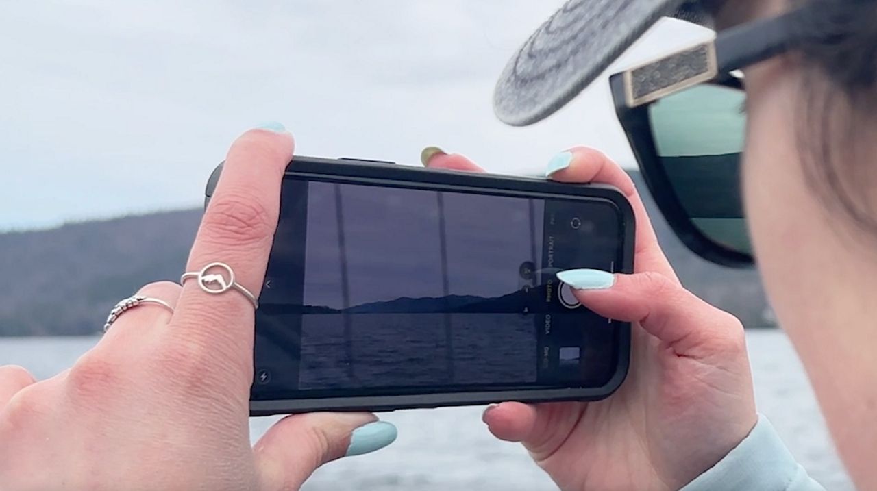 Photographer taking photos on her Iphone of Lake George.