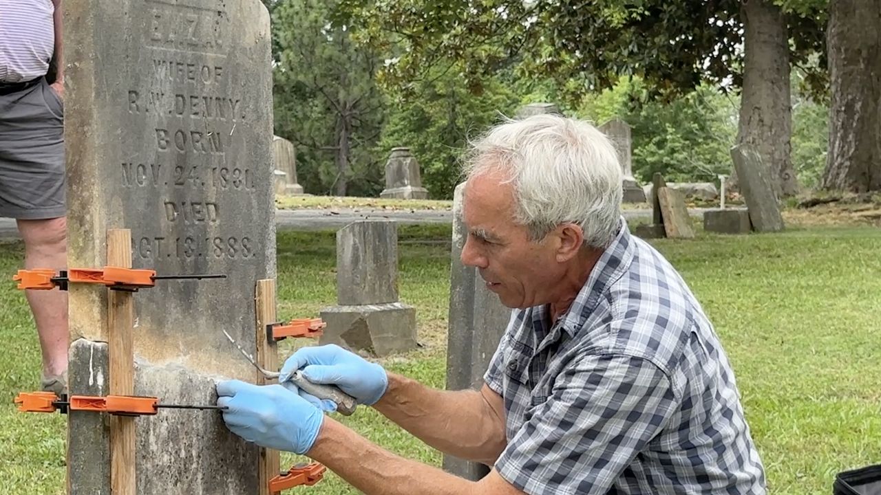 Jonathan Appell, showing how to correctly fix a broken gravestone.