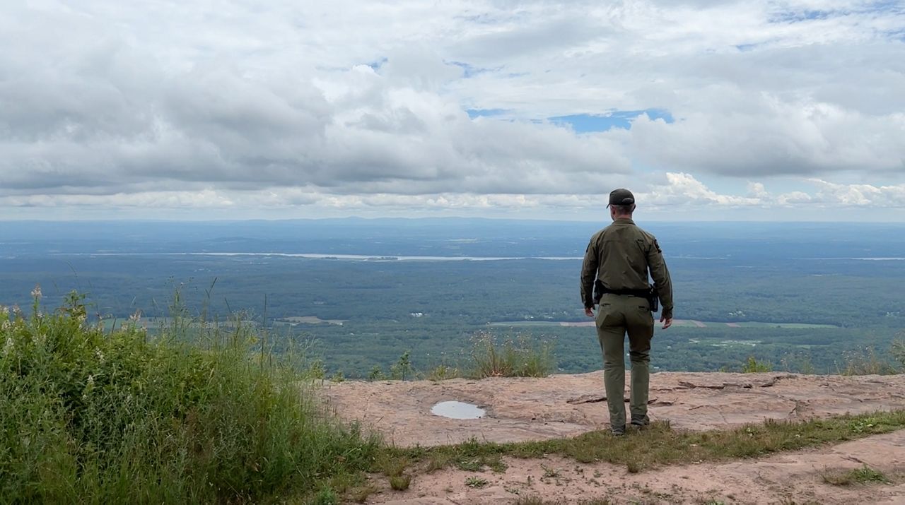 Forest ranger hiking a trail in upstate N.Y.