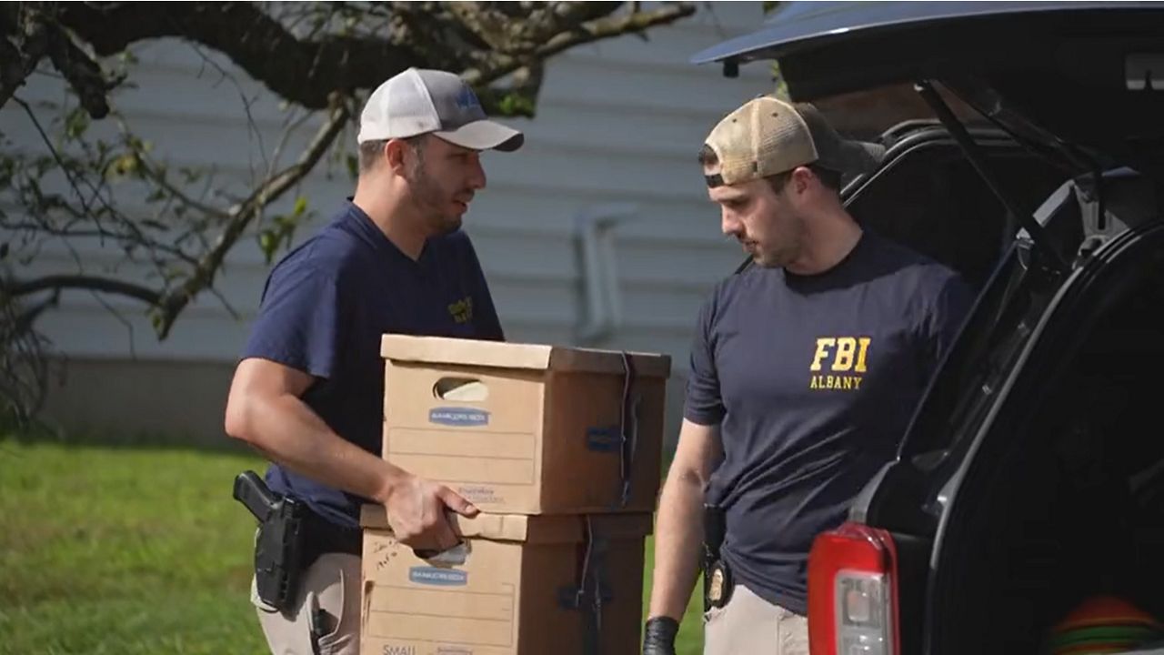 FBI agents carrying boxes