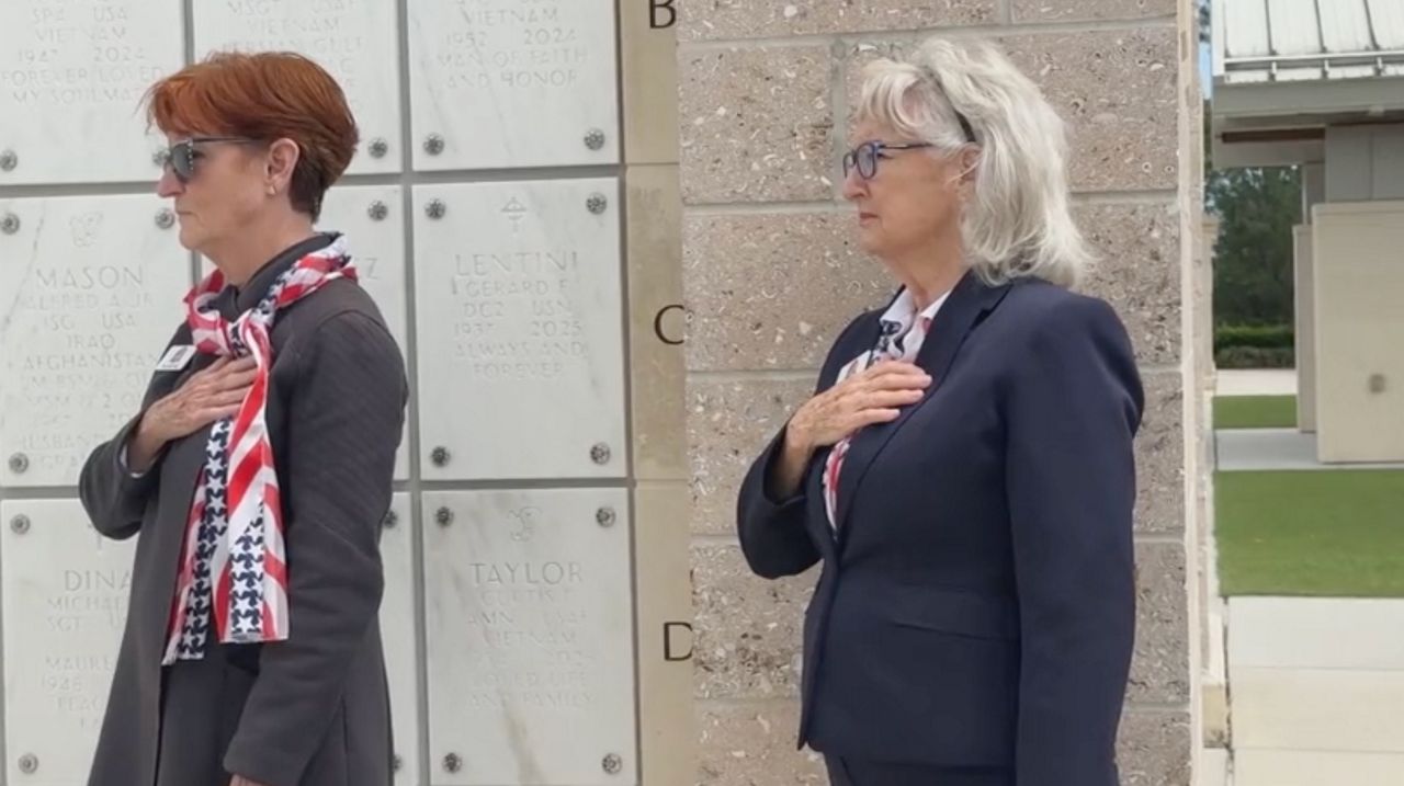 LaRue Fleming (right) and Sue Easterling, both volunteers with Cape Canaveral Ladies, attend a memorial service at Cape Canaveral National Cemetery. (Spectrum News)