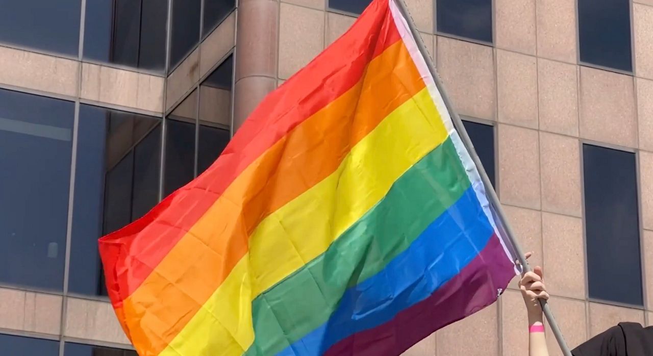 A person waving a Pride flag downtown Columbus during Columbus' Pride parade.