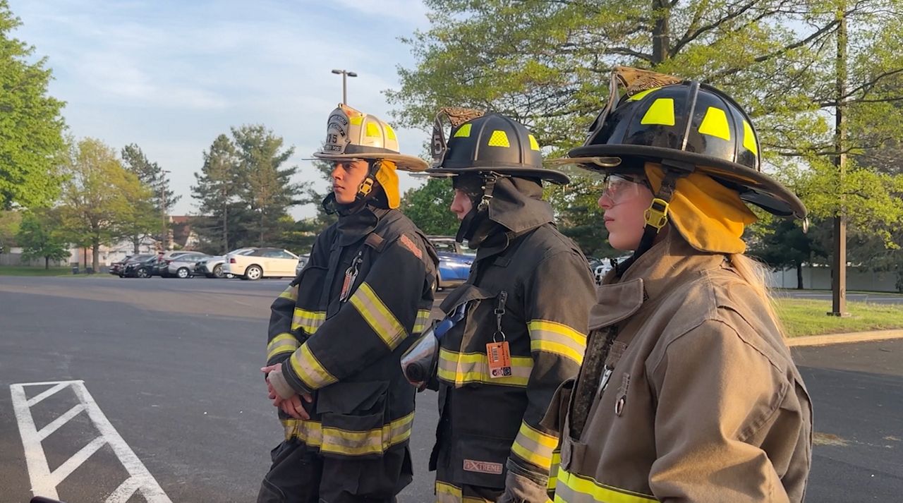 Explorer firefighters learning a drill.