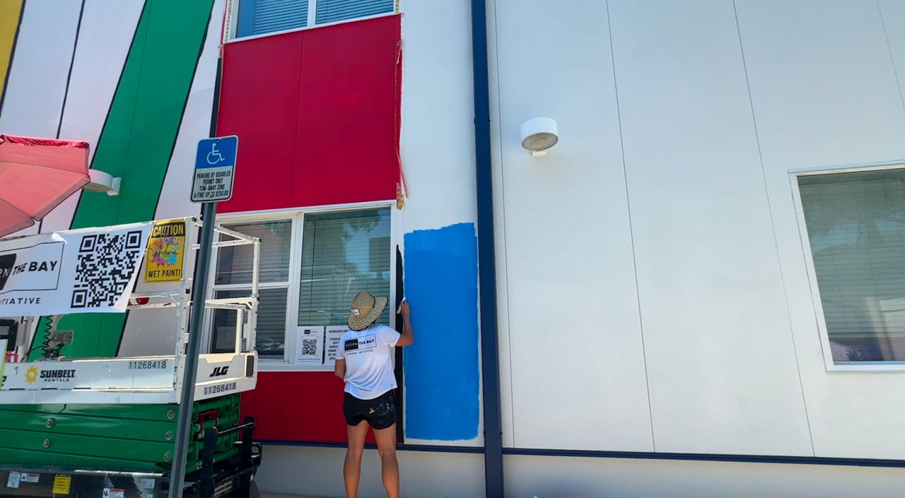Jessica Henson paints a mural. (Spectrum Bay News 9/Saundra Weathers)