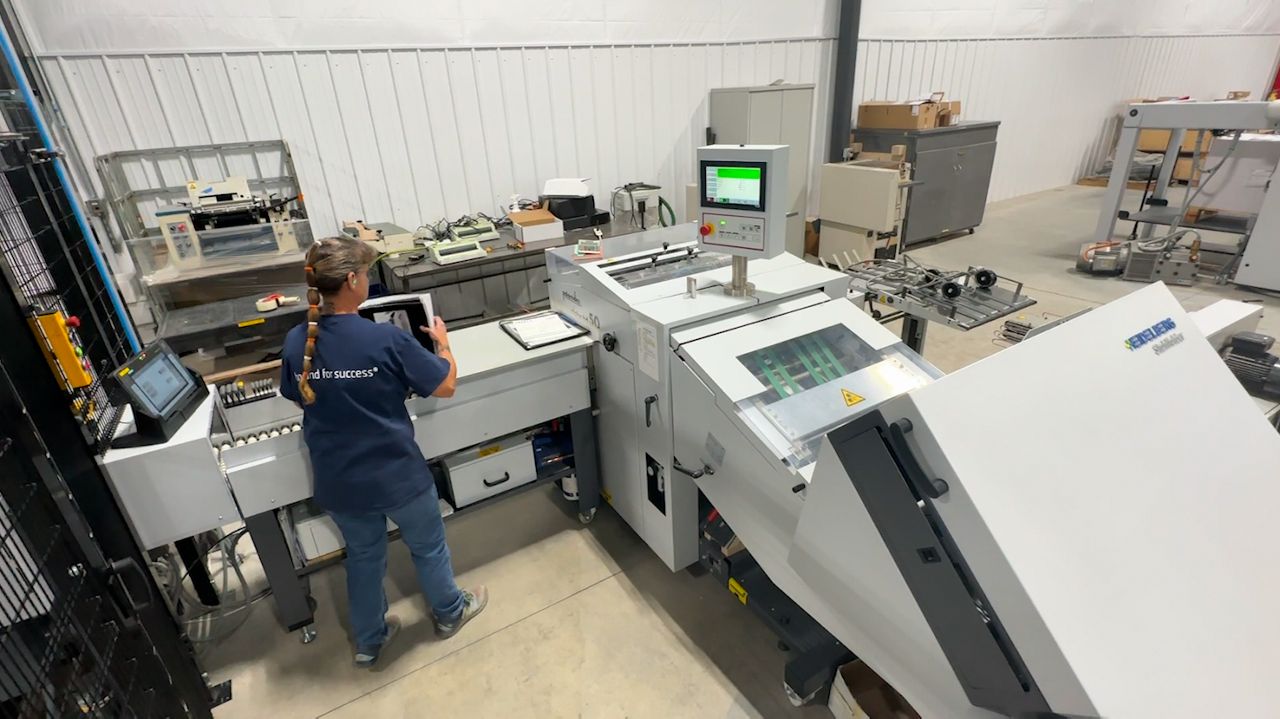 Gerette Butler works on a folding machine at Seaway Printing in De Pere, Wisconsin.