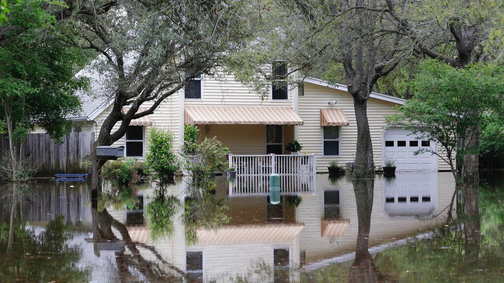 A home remains in water despite receding flood waters, Thursday, May 1, 2014, in Gulf Breeze, Fla. (AP Photo/John Raoux, File)