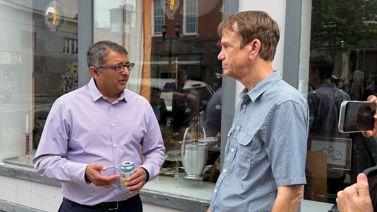 Dr. Nirav Shah speaks with a member of the public on Tuesday in Biddeford shortly before a press event. (Spectrum News/Susan Cover)