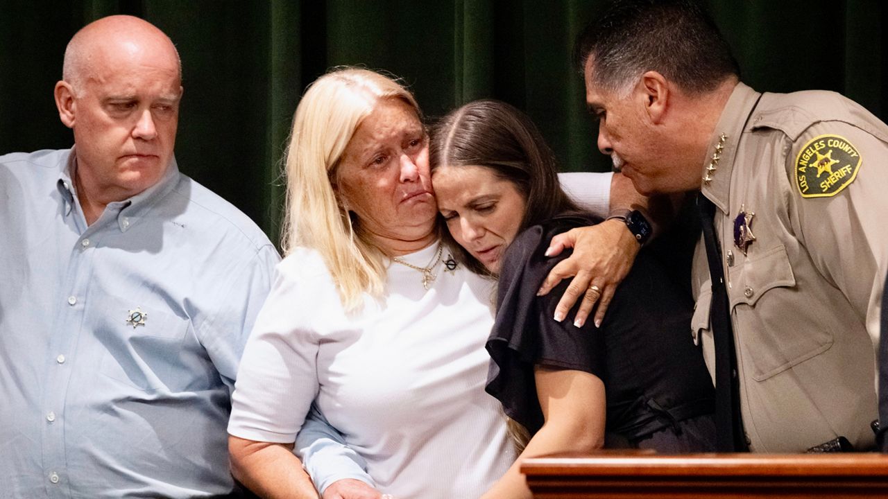 Los Angeles County Sheriff Robert Luna, right, comforts sheriff’s deputy Ryan Clinkunbroomer’s fiancee Brittany Lindsey, second from right, joined by Clinkunbroomer’s parents, Kim and Mike Clinkunbroomer, during a news conference at the Hall of Justice in downtown Los Angeles on Sept. 20, 2023. (AP Photo/Richard Vogel)