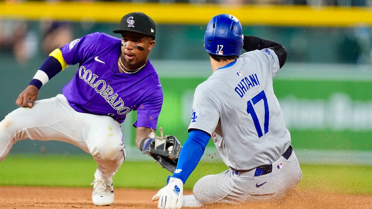 Los Angeles Dodgers' Shohei Ohtani, right, slides safely into second base for a steal as Colorado Rockies second baseman Adael Amador, left, fields the throw in the eighth inning of a baseball game Monday, June 17, 2024, in Denver. (AP Photo/David Zalubowski)