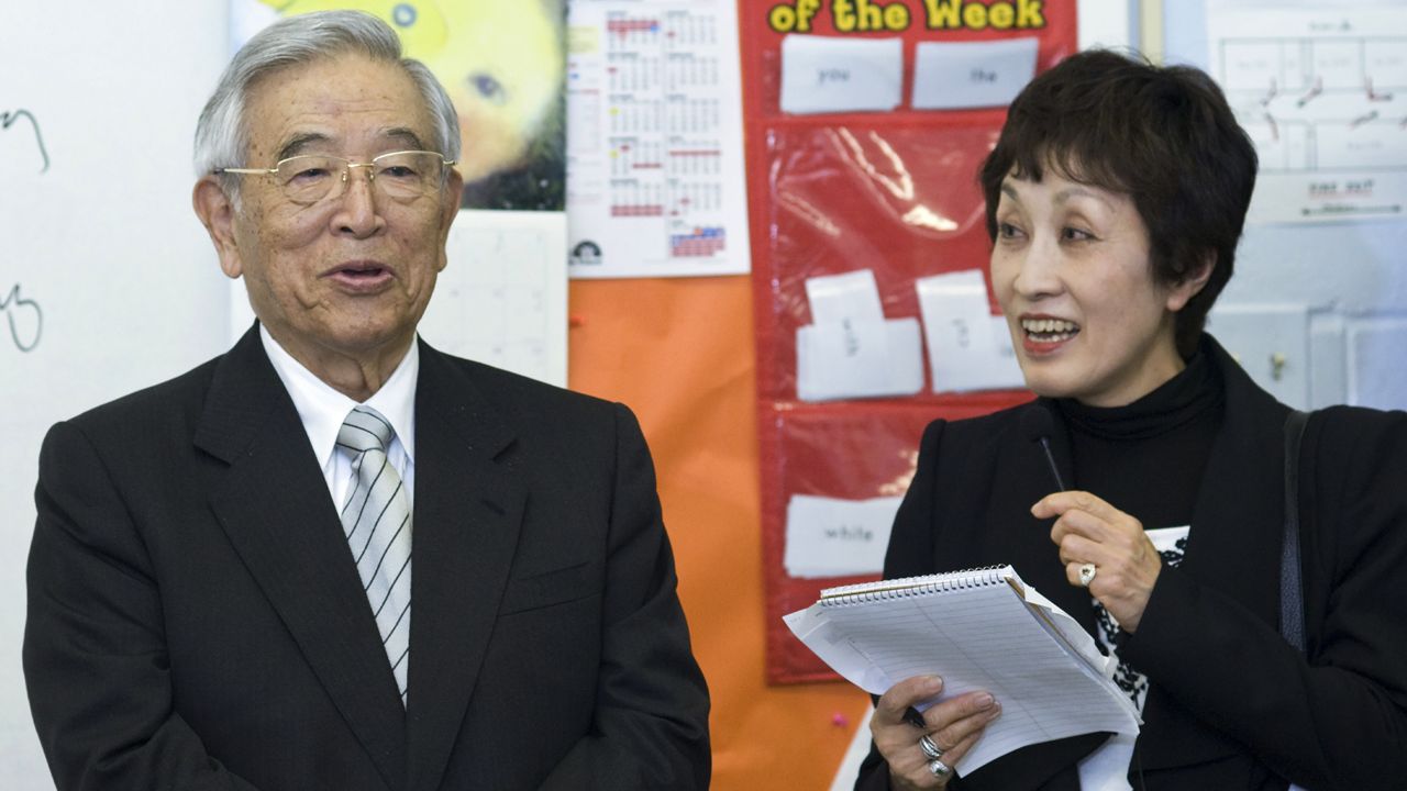 Dr. Shoichiro Toyoda, center, then honorary chairman of Toyota with his translator Ms. Morita, left, speaks to a classroom at St. Bartholomew School on April 4, 2011, in Louisville, Ky., during a tour to observe students and parents participating in Toyota's Family Literacy Program. (AP Photo/Brian Bohannon)