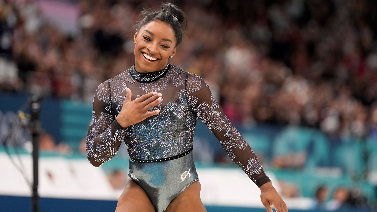 Simone Biles competes on the balance beam during a women's artistic gymnastics qualification round at the 2024 Summer Olympics at Bercy Arena, Sunday, July 28, 2024, in Paris, France. (AP Photo/Abbie Parr)