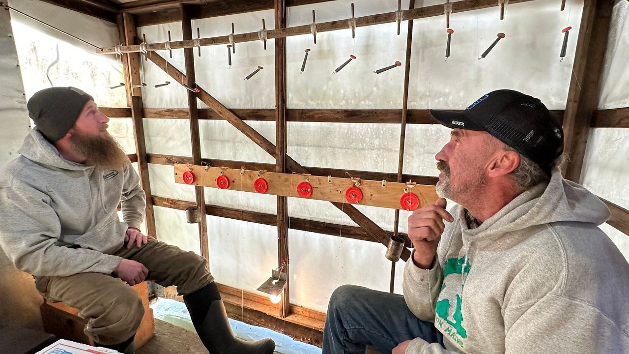 Jeremy Brewer, 38, of Dresden, left, and Vincent Toth, 61, of Greene, enjoy a day out on the ice hoping for the smelt to bite. (Spectrum News/Susan Cover)